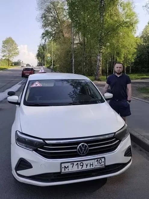 Инструктор Олег Иванович у белого учебного автомобиля Volkswagen Polo